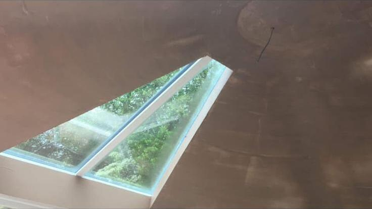 Freshly skimmed pink plaster finish on a vaulted ceiling around a skylight by SJM Plastering